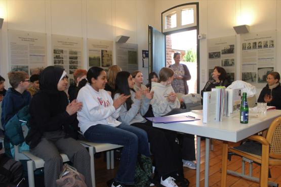Martine Letterie betritt den Vortragsraum, nach dem sie die „Denkmale für Leo“ kommentiert hatte. Die Klasse 6 des Gymnasiums Georgianum spendet begeistert Beifall.