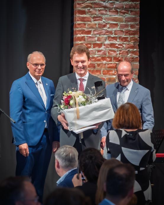Ein Dankeschön zum Abschied: Der Erste Bürgermeister Stefan Heskamp (links) und der Erste Stadtrat Lothar Schreinemacher (rechts) überreichten Dieter Krone bei seiner offiziellen Verabschiedung unter anderem einen goldenen Taktstock.