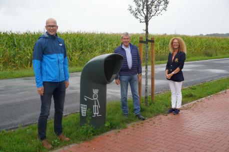 Freuen sich, dass die neuen Abfallkörbe schon gut angenommen werden: (v. li.) der Leiter des Bauhofs Christian Schulte, Ortsbürgermeister Werner Hartke und die Vertreterin des Unternehmens und Gebietsleiterin Sule Kilinc. 