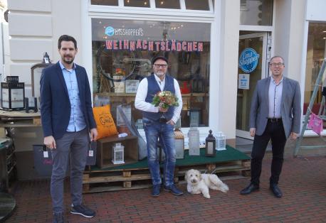 Statt einem Weihnachtswäldchen gibt es in diesem Jahr ein EmsShopper-Weihnachtslädchen: LWT-Geschäftsführer Jan Koormann (links) und Citymanager Andreas Löpker (rechts) gratulierten Matthias Lange zur Eröffnung des Pop-up-Stores. 