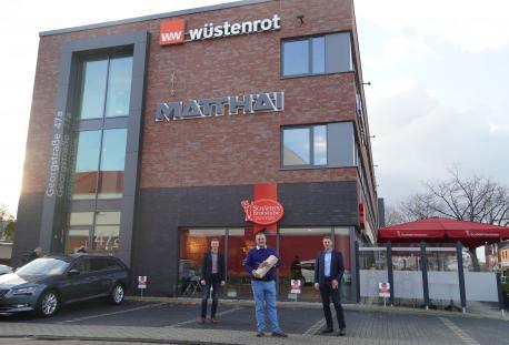 Neues Wüstenrot Vorsorge-Center an der Georgstraße: Wirtschaftsförderer Dietmar Lager (links) und Immobilien-Inhaber Albert Bröskamp (rechts) gratulieren Wüstenrot-Verkaufsleiter Sascha Wieser zur Eröffnung des neuen Standortes.