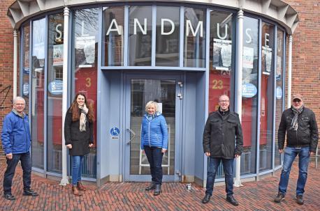 Über den neuen Adventskalender am Emslandmuseum freuen sich gemeinsam mit dem Museumsteam Marina Kollmann von der LWT und Citymanager Andreas Löpker von der Stadt Lingen.