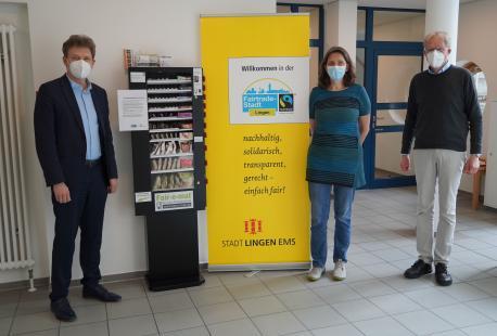 Oberbürgermeister Dieter Krone, Uta van Roje (Vorsitzende Weltladen Lingen) und Holger Berentzen (Sprecher Fairtrade-Steuerungsgruppe) testen den neuen Fair-o-mat im Foyer des Neuen Rathauses.