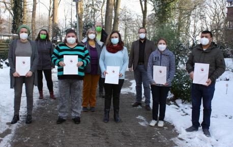 Fünf Qualifizierungsteilnehmende freuen sich über ihren erfolgreichen Abschluss (1. Reihe; v. l. n. r.): Sandra Smajilbasic, Jasmin Beetzen, Daniela Radies, Bianca Mittelstädt, Adel Alfarho. Dahinter (v. .l. n. r.): Susanne Plescher (Dozentin für Pflege und Betreuung; Grafschafter Gesundheitspraxis), Eva Paetzold (Projektleitung „QUEBE“), Michael Rammelkamp (Dozent für Pflege und Betreuung; Grafschafter Gesundheitspraxis) und Frank Surmann (Leiter des Bereiches ‚Berufliche Bildung und Arbeit‘ im