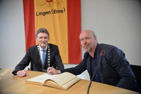 Oberbürgermeister Dieter Krone (li.) dankt Vladimir Slivyak (re.), der sich in das Goldene Buch der Stadt Lingen einträgt.