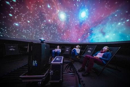 Auf bequemen Liegestühlen können die Besucher des Pop-Up-Planetariums ihre Reise in die unendlichen Weiten des Weltraums unternehmen.