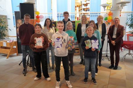 Die Jury des diesjährigen Bezirksentscheids Weser-Ems Süd zusammen mit Martin Berghane (links außen) und Dr. Heidrun Derks vom Museum Kalkriese (rechts außen), den Siegern sowie einigen Teilnehmern des diesjährigen Wettbewerbs: (v. li.) Teilnehmerin Mia Hase, Mandy Noetzel (Fachstelle für katholisch-öffentliche Bibliothe-ken Meppen), Sieger Mika Ekelhoff, Livius Fahlbusch (Sieger 2022), Teilnehmerin Maria Mondwurf, Andrea Thal (ehemals Buchhandlung Holzberg), Sieger Jakob Schnebel, Teilnehmerin 