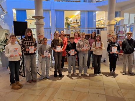 Die Teilnehmerinnen und Teilnehmer des Kreisentscheids des Vorlesewettbewerbs in der Stadtbibliothek Lingen mit Jury und Vorjahressieger. Der erste Platz ging an Lea Kamps vom Gymnasium Georgianum (3. von links).
Vorne (v. li.): Charlotte Fanta (Franziskusgymnasium Lingen), Ida Finke (Liudger-Realschule Emsbüren), Lea Kamps (Gymnasium Georgianum, Siegerin), Elisa Brosig (Friedensschule Lingen), Michel Klaas (Franziskus-Demann-Oberschule Freren), Jannes Schmit (Oberschule Spelle), Emma Fübbeker 