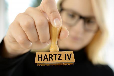 Mitarbeiterin mit Hartz IV Stempel in der Hand