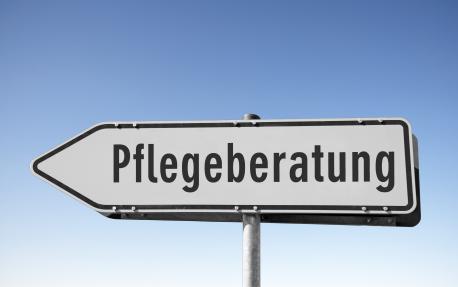 Das Bild zeigt ein Schild in Form eines Pfeils mit dem Schriftzug Pflegeberatung. 